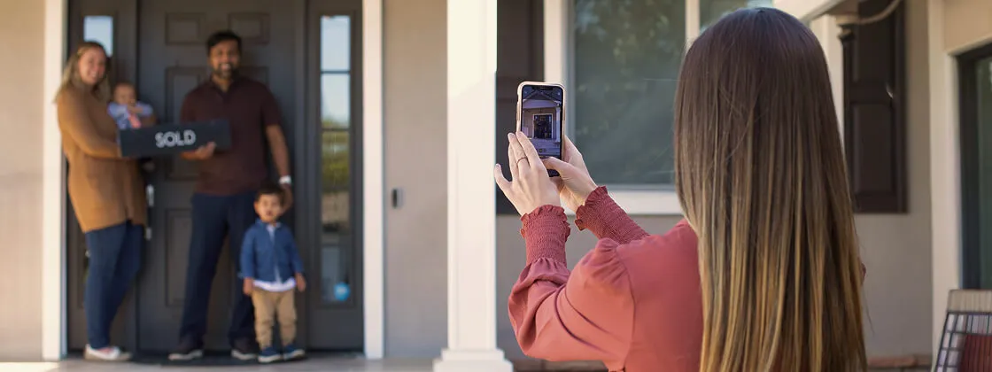 Realtor Monica Thomas taking a picture of her happy clients